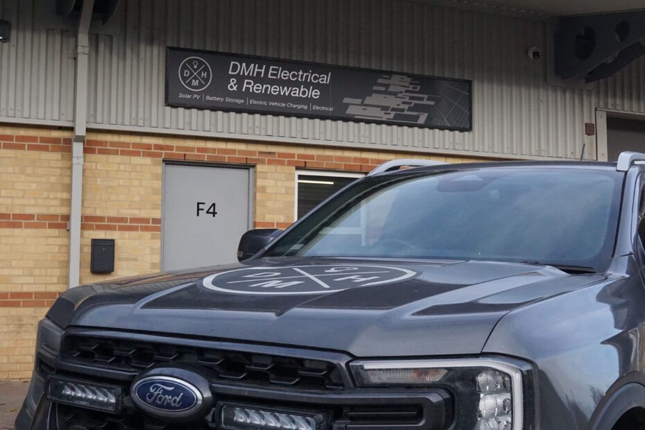 Image of the DMH offices with signage and company vehicle.